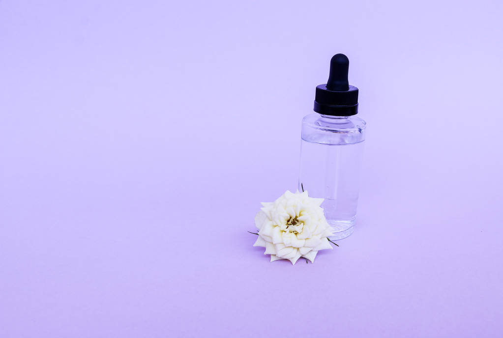 Стеклянная бутылка с пипеткой с маслом или сывороткой, с белым розовым гриппом
 - Фото, изображение