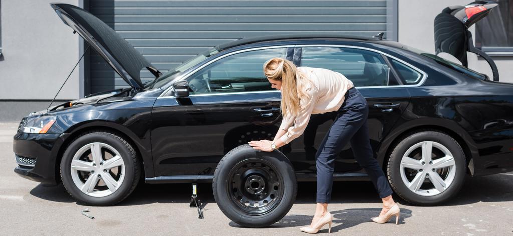 businesswoman toczenia nowe koło i mocowania złamane Auto, koncepcja ubezpieczenia samochodu - Zdjęcie, obraz