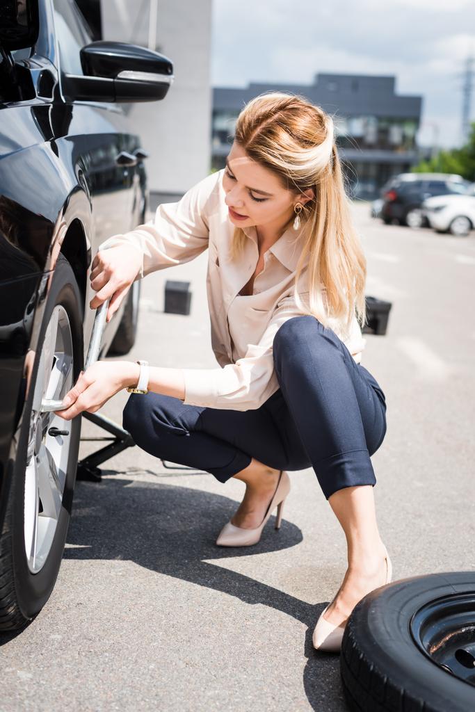 бізнес-леді фіксує колесо на зламаному автомобілі, концепція страхування автомобілів
 - Фото, зображення