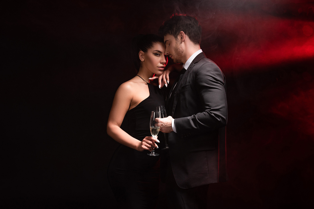 schöne stilvolle Paar mit Gläsern Champagner auf schwarz - Foto, Bild