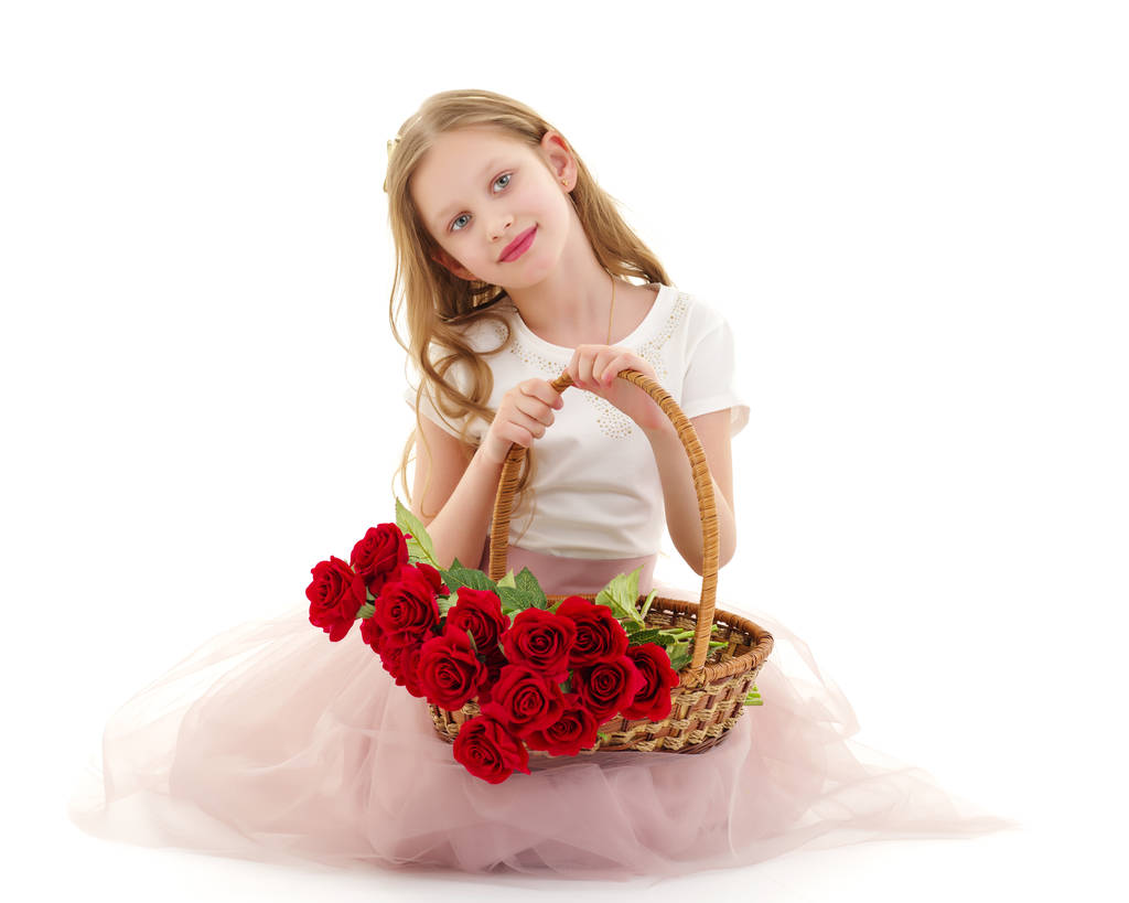 Schattig klein meisje met een mandje met bloemen. - Foto, afbeelding