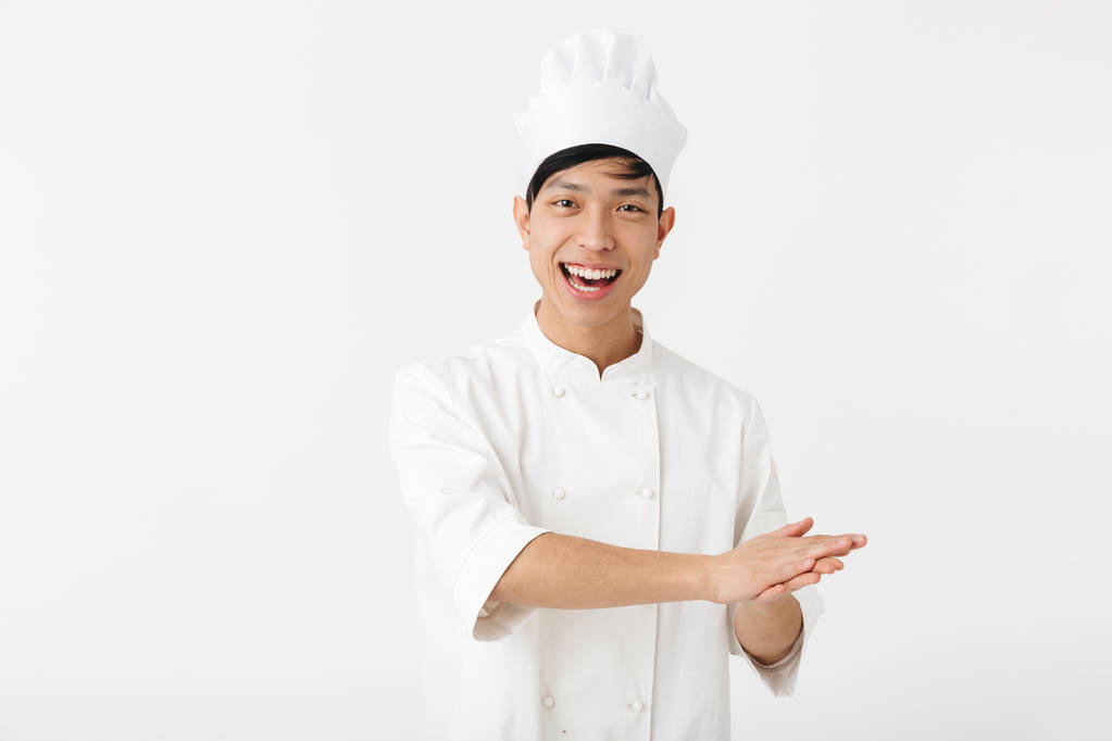 Portrait of happy chinese man in white cook uniform and chef's h - Photo, Image