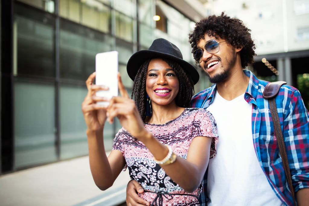 junges afrikanisches Paar macht ein Selfie und amüsiert sich im Freien. - Foto, Bild