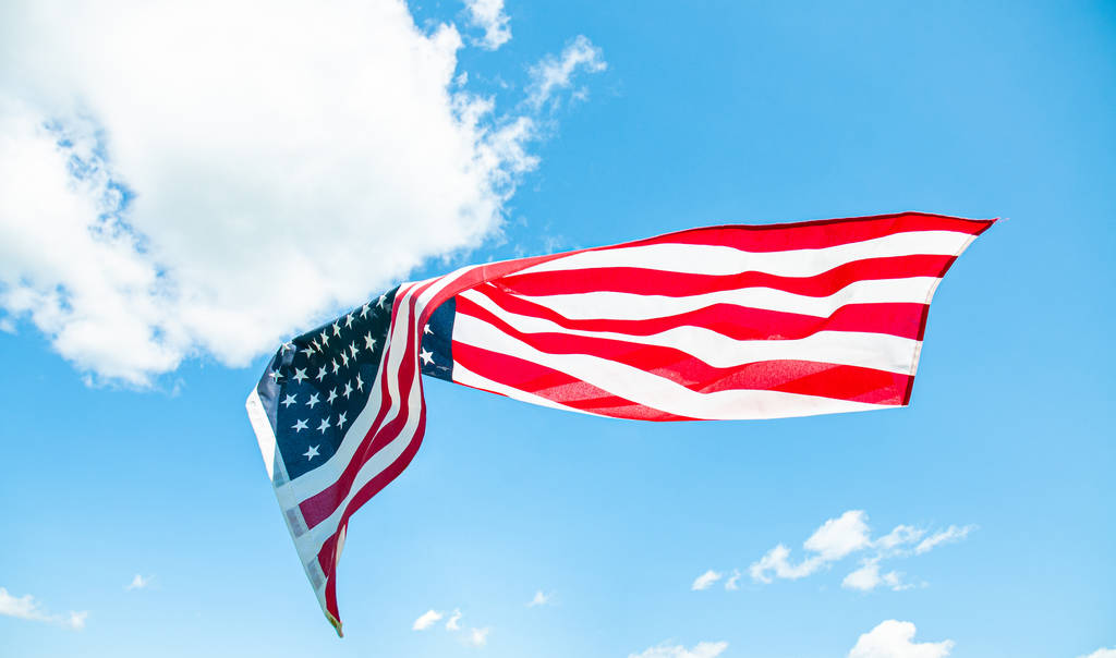 Американский флаг на голубом фоне неба. Флаг США
 - Фото, изображение