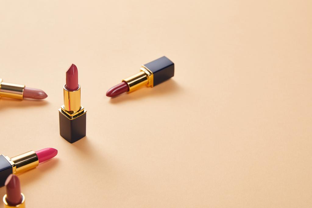 varios tonos rojos de lápices labiales en beige con espacio para copias
 - Foto, imagen