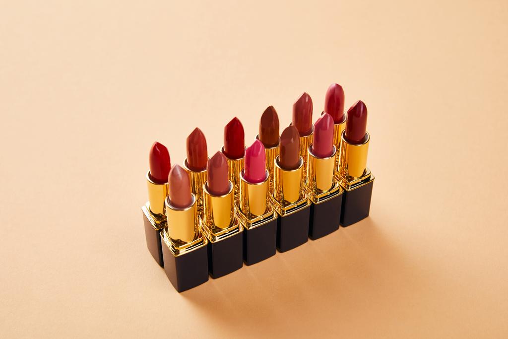 various shades of lipstick in tubes on beige  - Photo, Image