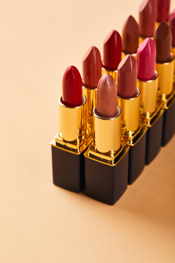closeup of shades of lipstick in tubes on beige  - Photo, Image