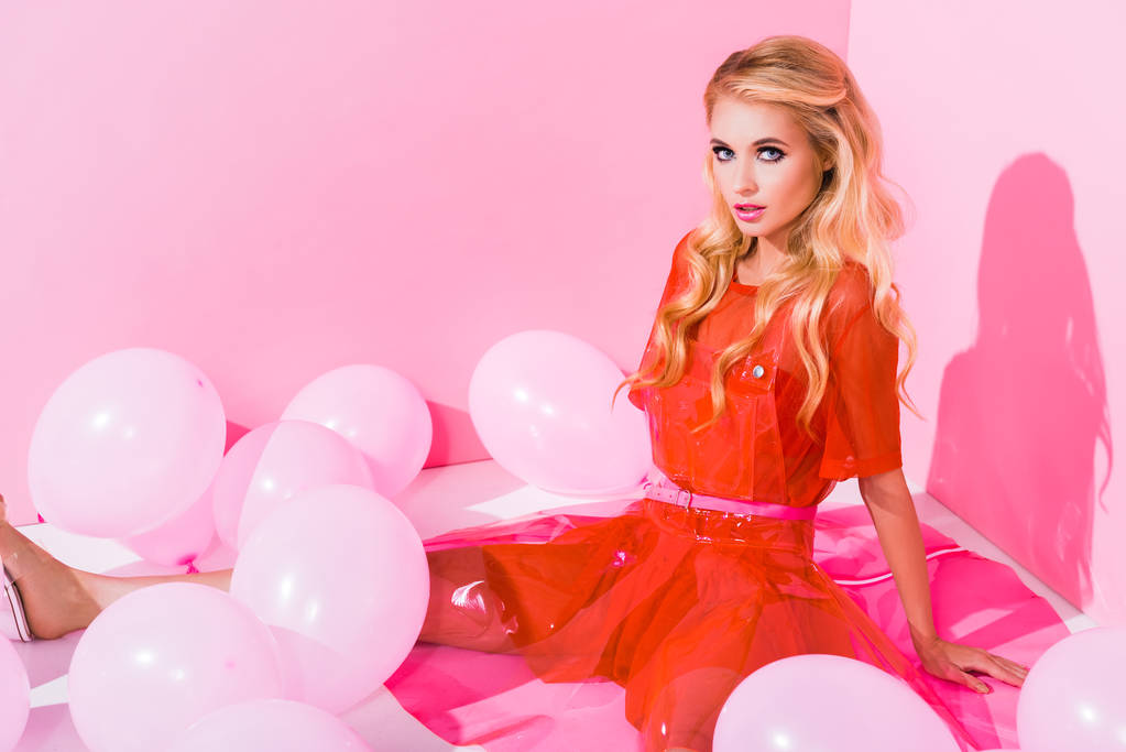mooi meisje poseren in de buurt van ballonnen op roze, pop concept - Foto, afbeelding