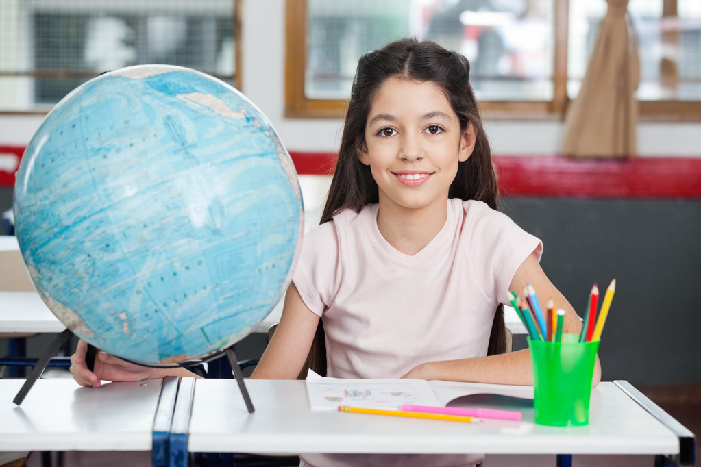 Schülerin lächelt mit Globus und Organisator am Schreibtisch - Foto, Bild