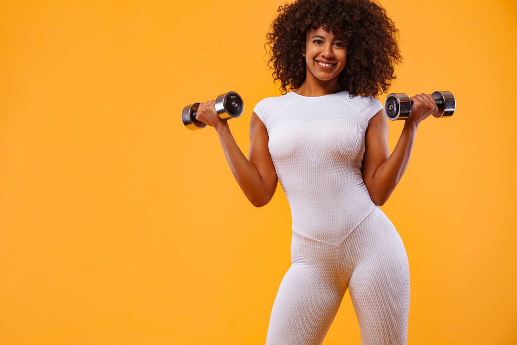Donna in forma sportiva, atleta con manubri fa esercizio di fitness su sfondo bianco. Fitness e motivazione del lavoro
. - Foto, immagini