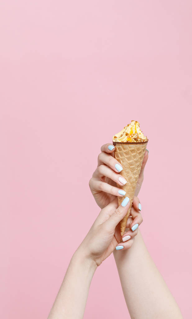 Donna che tiene gelato in un cono di cialde su sfondo di colore
. - Foto, immagini