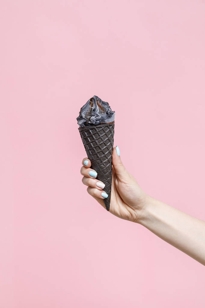 Woman holding Ice Cream in a waffle cone on color background. - Photo, Image