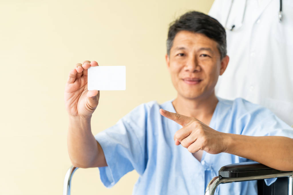 Asiatische Seniorin im Rollstuhl lächelt mit Kreditkarte - Foto, Bild