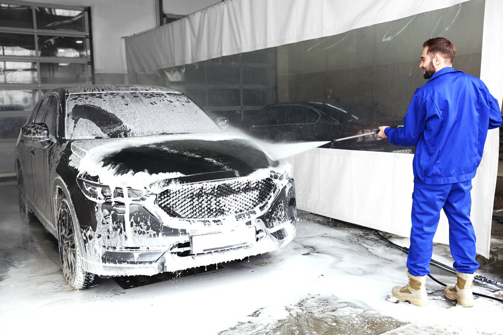 Munkás tisztítása automobil nagy nyomású vízsugár autómosó - Fotó, kép