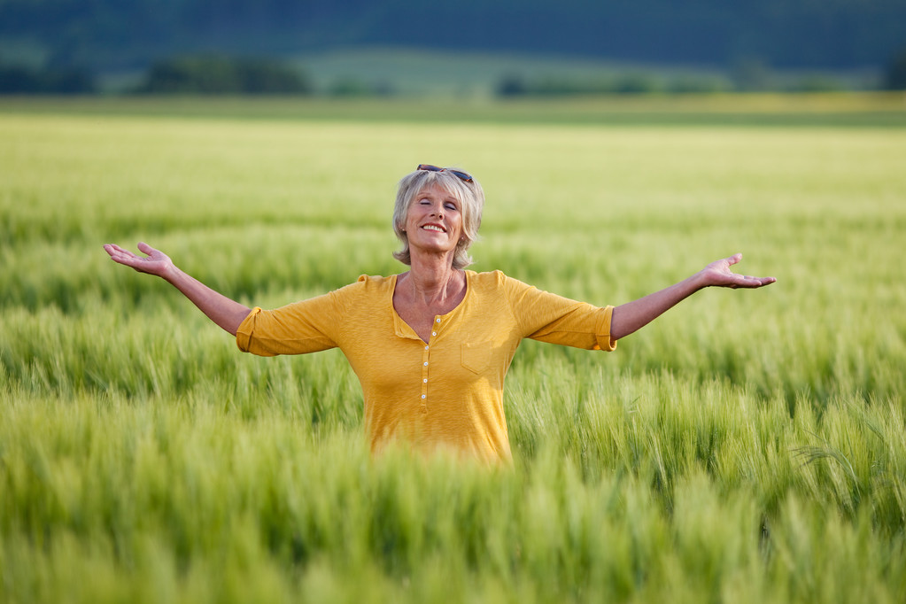 Mujer mayor disfrutando de la naturaleza en el campo de hierba
 - Foto, imagen