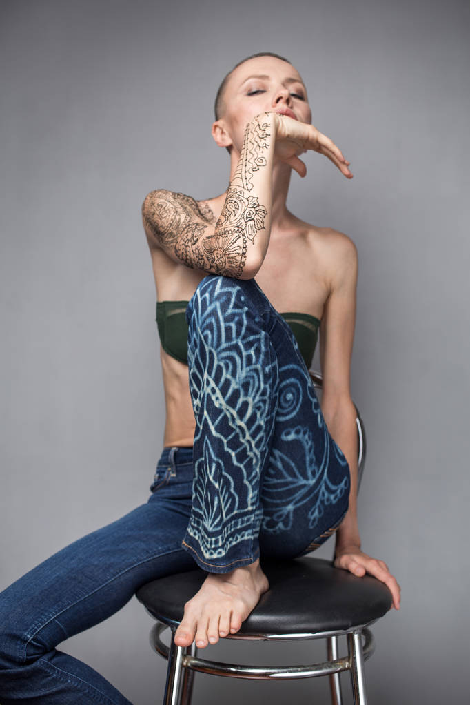 Skinhead ritratto donna con mehendi su un braccio e jeans
 - Foto, immagini