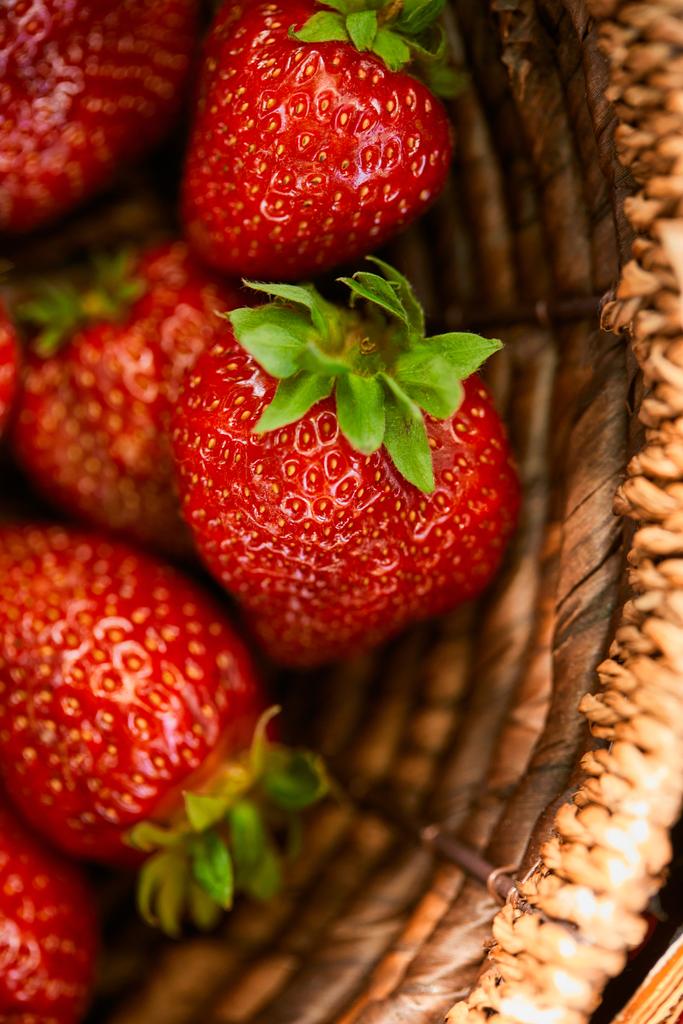 close up of sweet red strawberries in wicker basket  - Photo, Image
