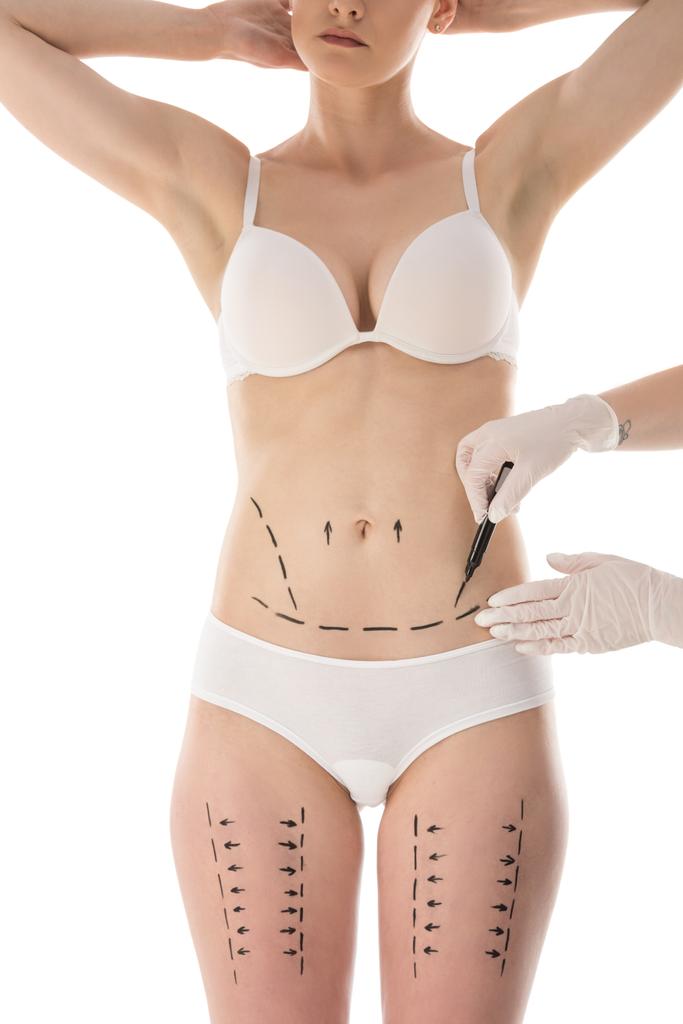 visão parcial do cirurgião plástico em luvas de látex fazendo marcas no corpo isolado em branco
 - Foto, Imagem