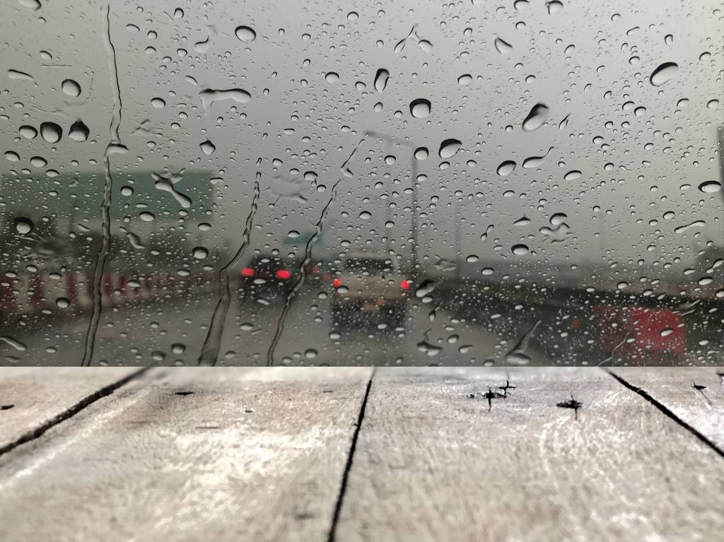 panneaux en bois devant le pare-brise de la voiture avec des gouttes de pluie sur fond de rue floue avec la circulation en ville le jour de pluie
 - Photo, image