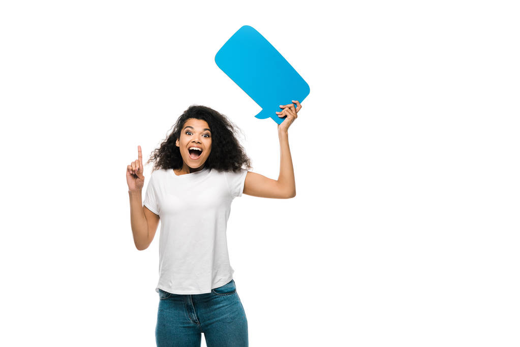 happy african american girl holding blue speech bubble while pointing with finger isolated on white  - Photo, Image