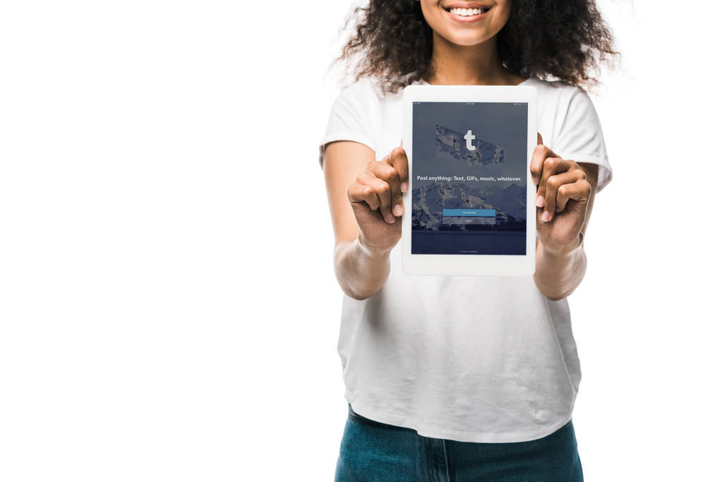 KYIV, UCRANIA - 29 de mayo de 2019: vista recortada de la feliz chica afroamericana sosteniendo una tableta digital con aplicación tumblr en la pantalla aislada en blanco
  - Foto, imagen