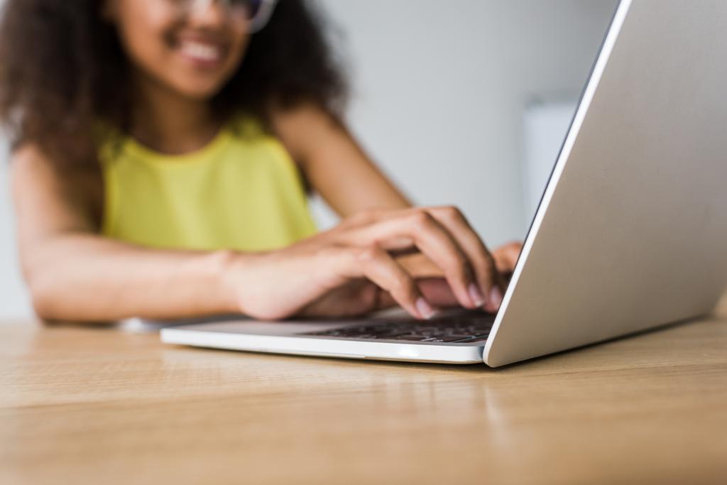  dizüstü bilgisayar kullanarak mutlu Afrikalı-Amerikalı kadının seçici odak - Fotoğraf, Görsel