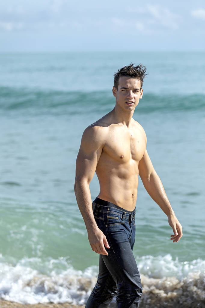 Giovane uomo muscoloso bello in riva al mare in una giornata di sole
 - Foto, immagini