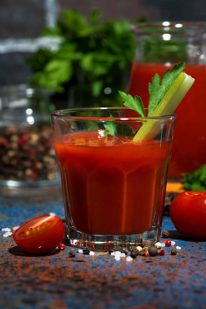 свіжий томатний сік з сіллю і селерою на темному столі, вертикальний
  - Фото, зображення