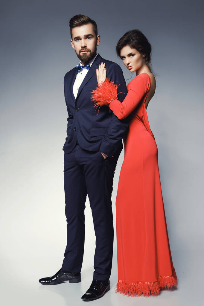 Vrouw in mooie rode jurk en man dragen blauwe klassieke pak - Foto, afbeelding