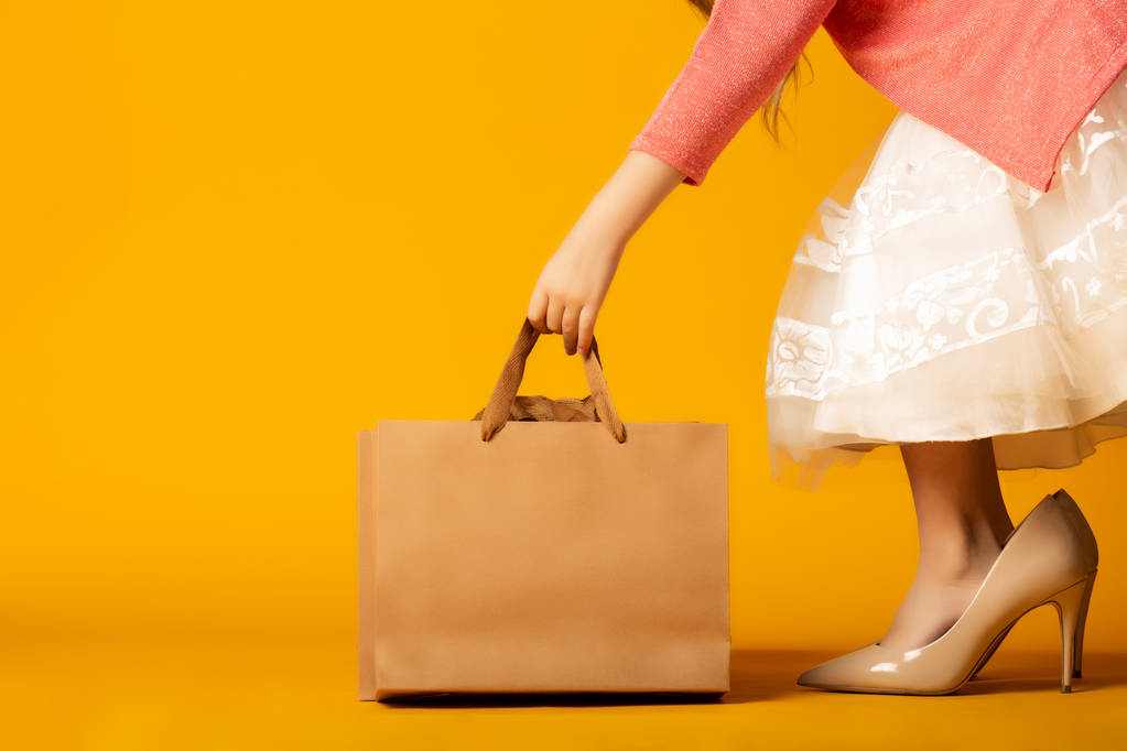 jeune femme avec sac à provisions sur fond jaune
 - Photo, image