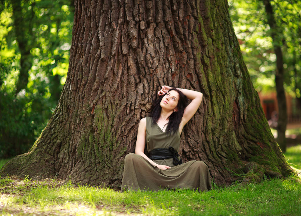 Девушка в платье сидит наслаждаясь природой медитирует, практикует йогу
 - Фото, изображение