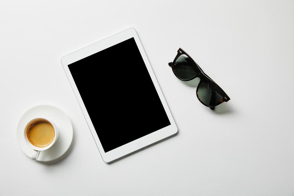 vista dall'alto di tablet digitale, caffè e bicchieri su superficie bianca
 - Foto, immagini