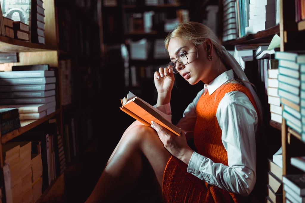 krásná a blondýnka v brýlích a četbě knih v knihovně  - Fotografie, Obrázek