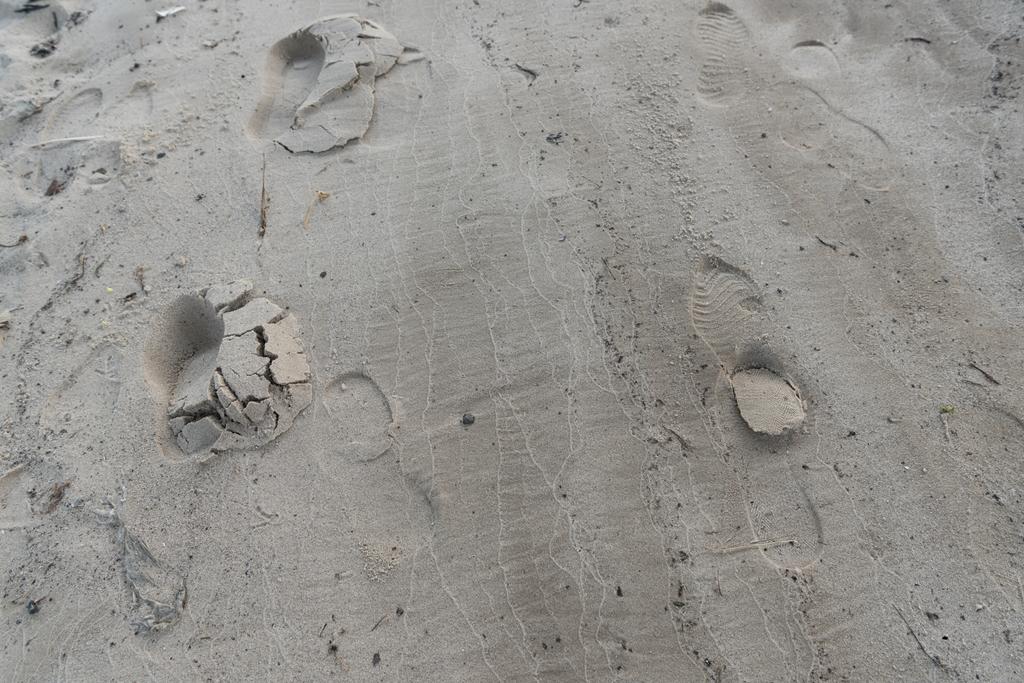 вид сверху на текстурированный коричневый песок с человеческими следами
 - Фото, изображение