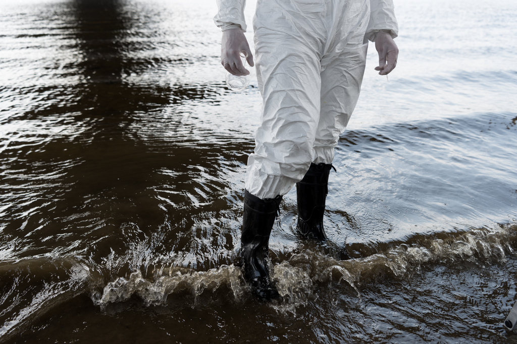 partial view of water inspector in protective costume and boots standing in river - Photo, Image
