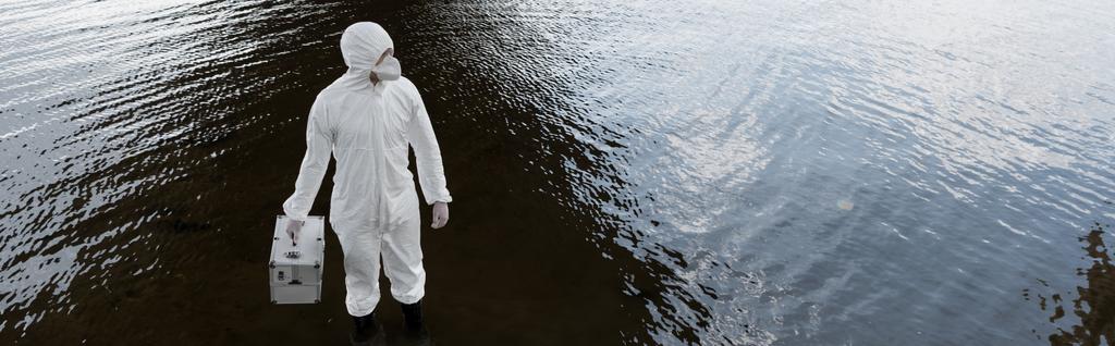 colpo panoramico di ispettore dell'acqua in costume protettivo e kit di ispezione respiratore tenuta al fiume
 - Foto, immagini