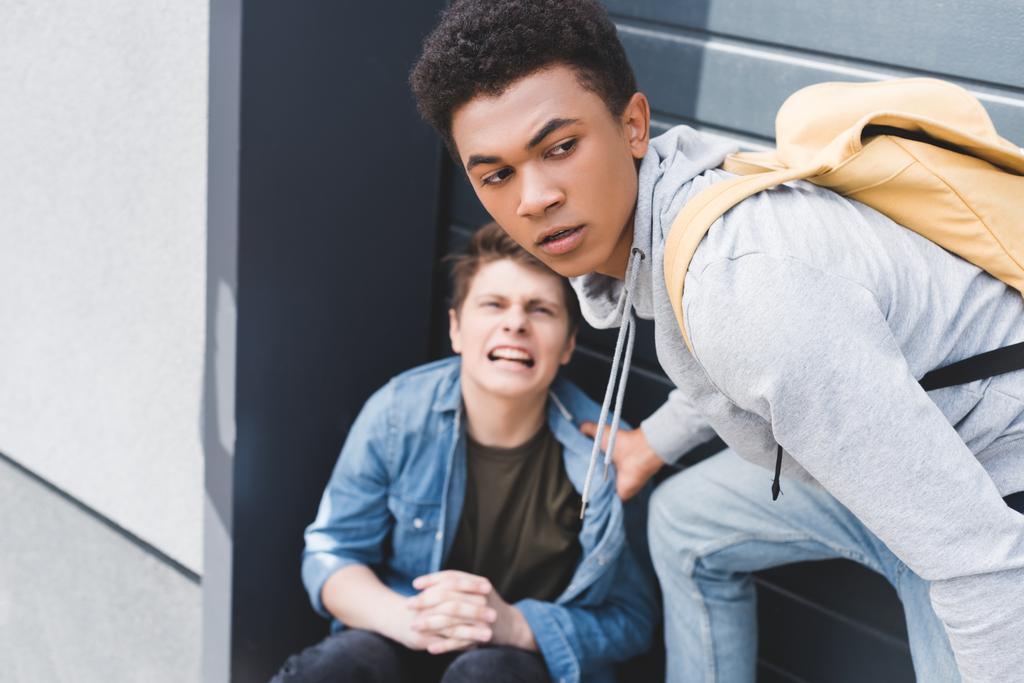 selectieve focus van Afro-Amerikaanse jongen in hoodie en jeans Bulling schreeuwen en bang jongen - Foto, afbeelding