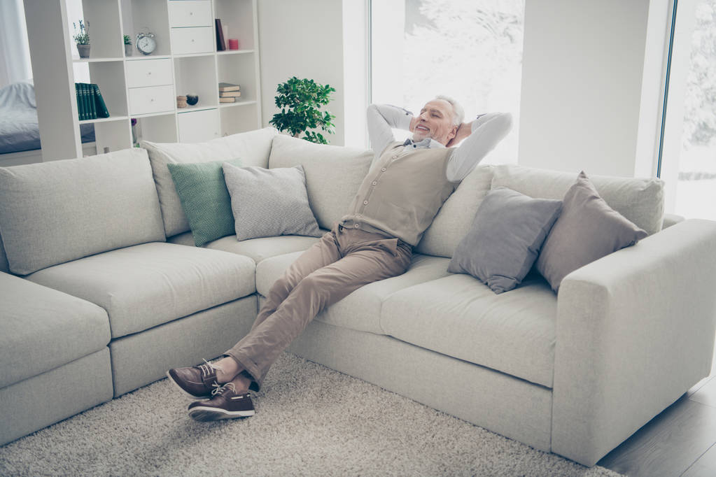 Full length body size photo amazing he him his aged man overjoyed calm hands arms behind head day off imaginary flight wear white shirt waistcoat pants sit cozy divan flat house living room indoors - Photo, Image
