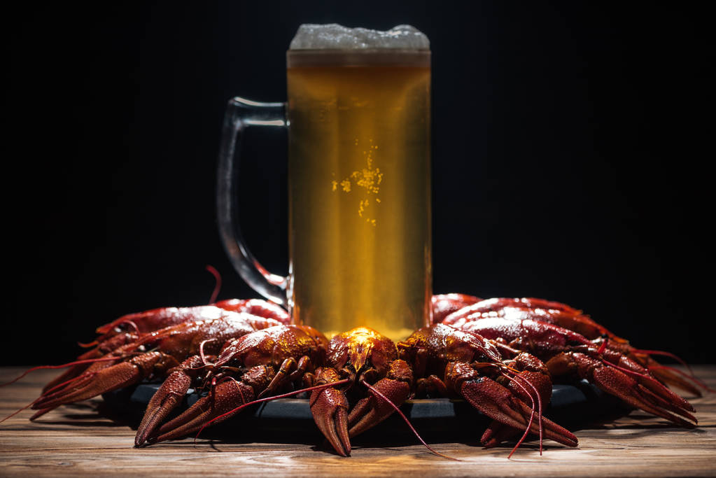 glass of beer on plate with red lobsters at wooden surface - Photo, Image