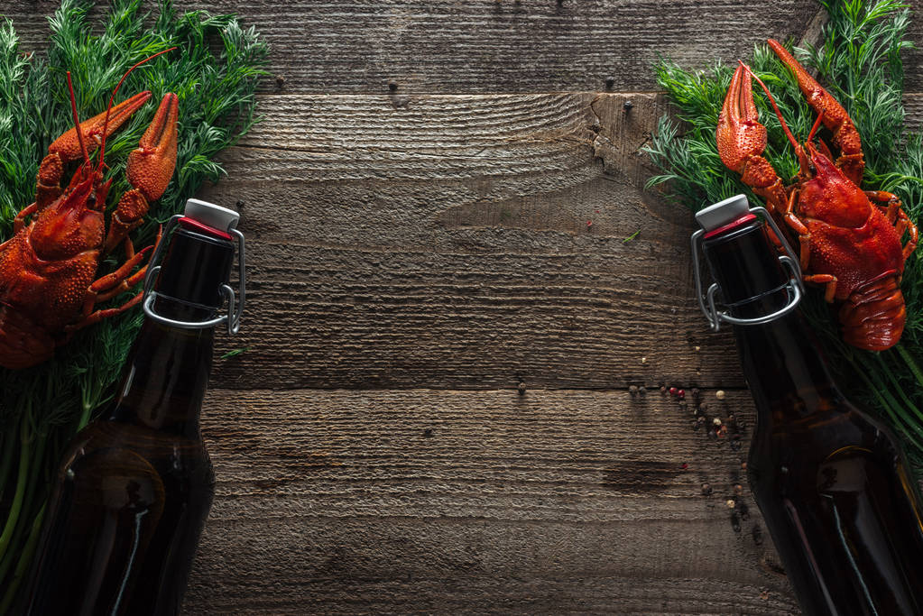 vista superior de langostas rojas, eneldo y botellas con cerveza en la superficie de madera
 - Foto, Imagen