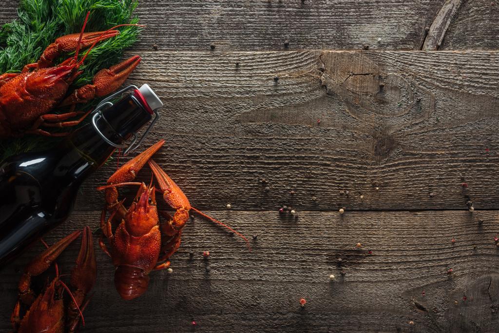 Widok z góry na czerwone homary, koperek i butelkę z piwem na drewnianej powierzchni - Zdjęcie, obraz