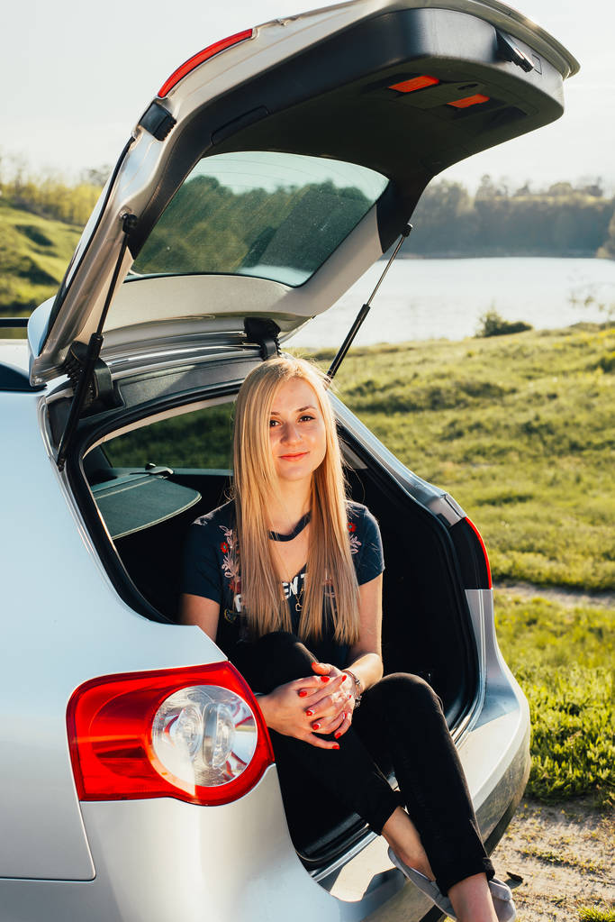 portrait de belle jeune femme assise dans le coffre de la voiture sur la nature
 - Photo, image