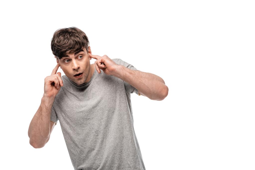 наляканий молодий чоловік дивиться геть, підключивши вуха руками ізольовані на білому
 - Фото, зображення