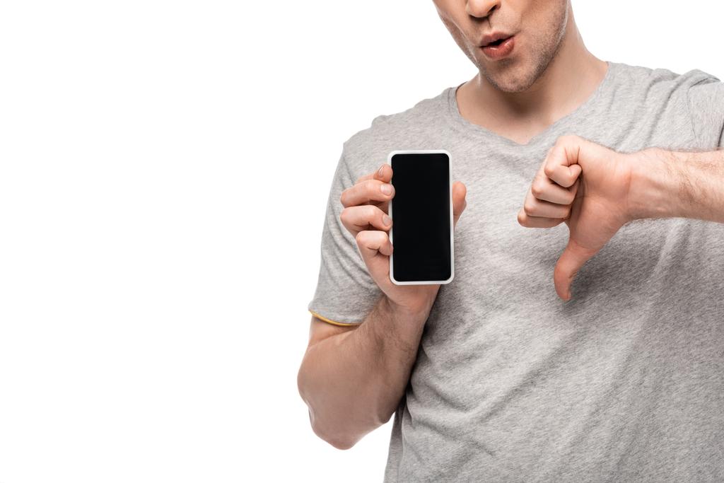 abgeschnittene Ansicht eines Mannes, der den Daumen nach unten zeigt, während er Smartphone mit leerem Bildschirm hält, isoliert auf Weiß - Foto, Bild
