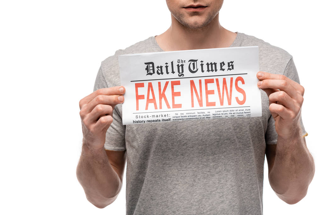 visão cortada de jovem mostrando jornal com notícias falsas isoladas no branco
 - Foto, Imagem