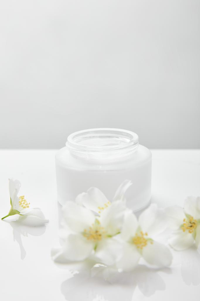 fiori di gelsomino su superficie bianca vicino vaso con crema
 - Foto, immagini