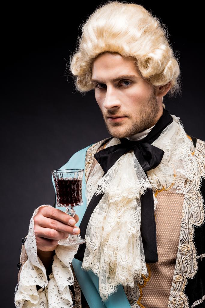 pomposo hombre victoriano en peluca sosteniendo copa de vino en negro
  - Foto, Imagen