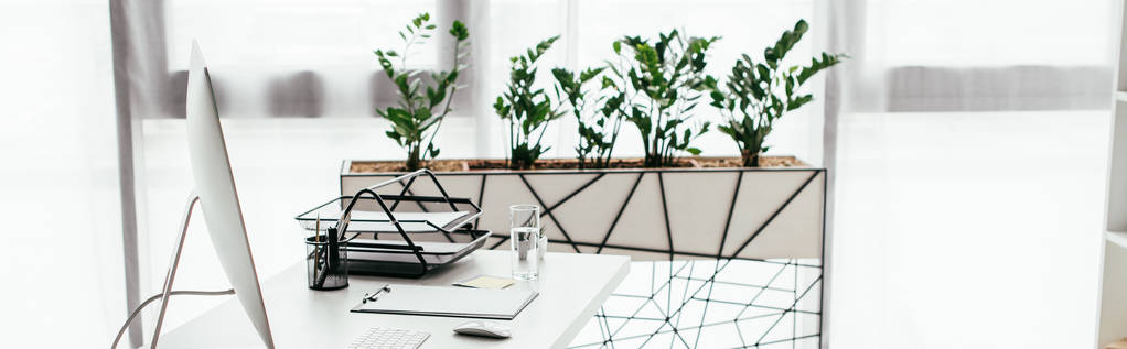 Panoramaaufnahme von Büro mit Tisch und Blumentopf mit Pflanze - Foto, Bild