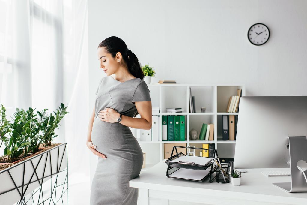 ofiste masanın yanında duran hamile kadın - Fotoğraf, Görsel
