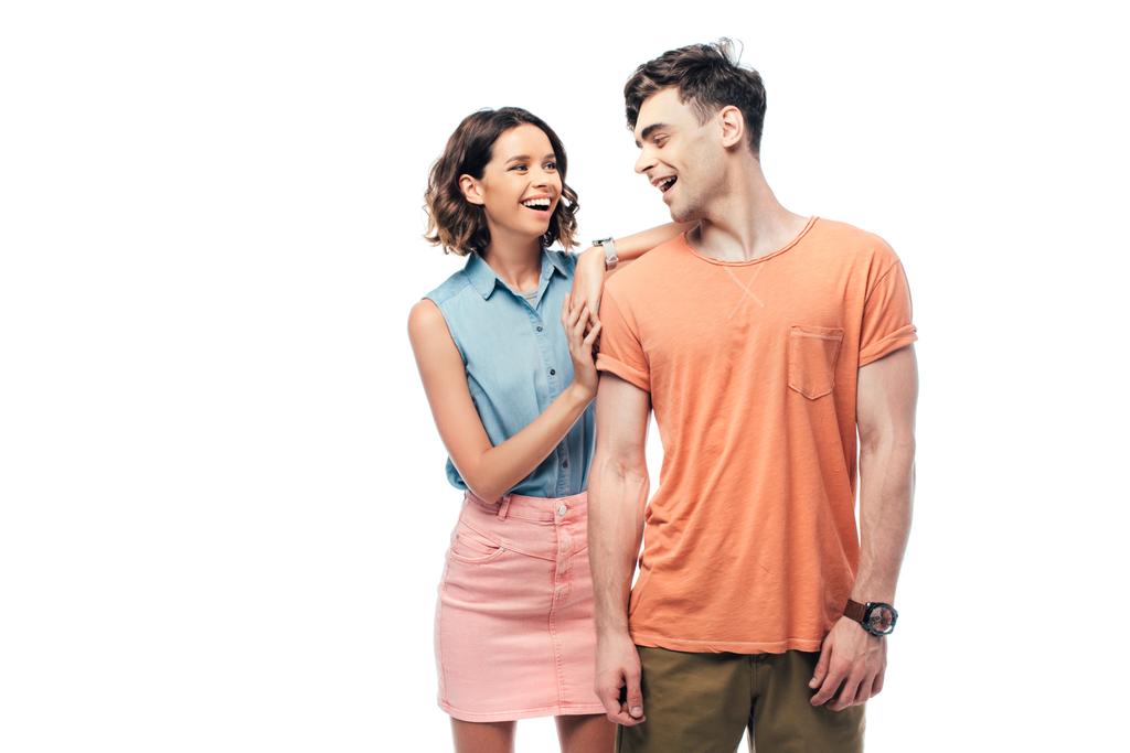 glückliches junges Paar lächelt, während es sich isoliert auf Weiß ansieht - Foto, Bild